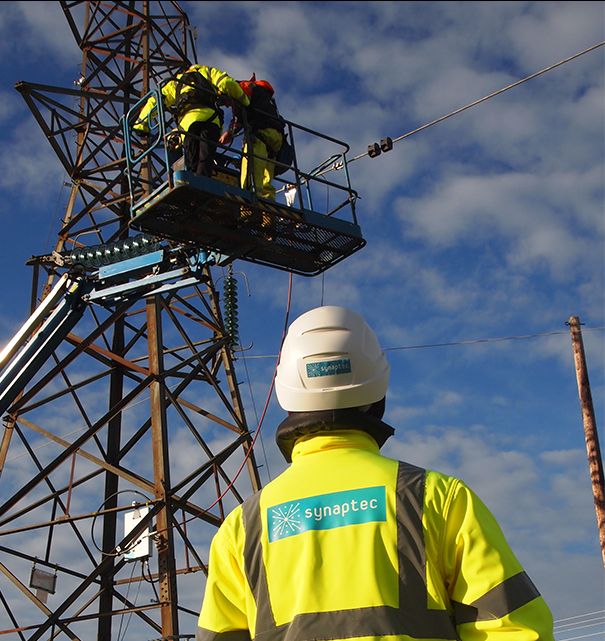 Synaptec engineer overseeing a sensor installation on a transmission tower